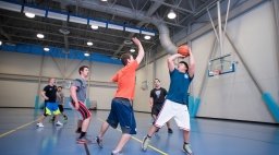 Students playing basketball inside gym